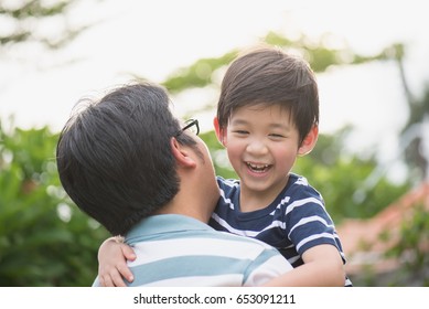 Asian Father Holding His Son In The Park