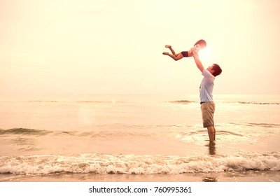 Asian Father And Little Girl Playing On The Beach At The Sunset, Dad Holding Daughter Flying At The Beach. Together Love Family Concept. Father's Day