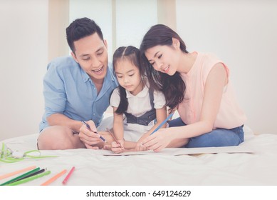 Asian Father And Mother Teaching Her Daughter Child To Studying At Home.