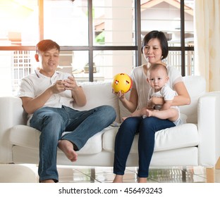 Asian Father Playing With Phone Ignoring His Family And Angry Wife