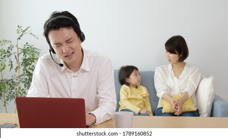 Asian Father Remote Working At Noisy Living Room