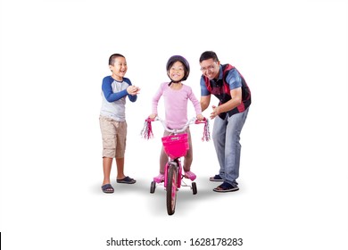 Asian father and son cheering and clapping for the girl which succeeded riding a bicycle while smiling at camera, isolated in white background - Powered by Shutterstock