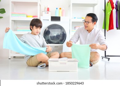 Asian father and son help each other doing laundry together for daily routine chores - Powered by Shutterstock