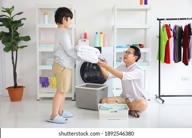 Asian father and  son help each other doing laundry together for daily routine chores 