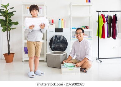 Asian father and son help each other doing laundry together for daily routine chores - Powered by Shutterstock