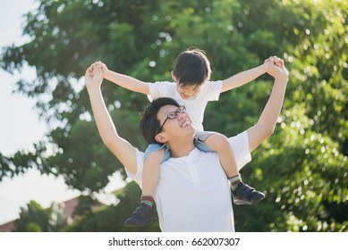 Asian Father And Son Playing In The Park