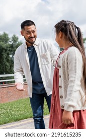 Asian Father Talking To Preteen Daughter In Park