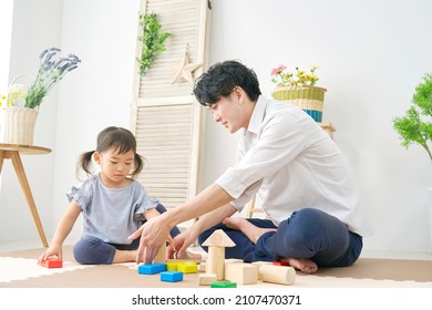 Asian Father And Their Daughter Playing With The Building Blocks At Home 