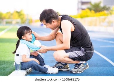 Asian Father Is Wiping Sweat For The Little Daughter And They Talking And Smile Together While Resting For Jogging Time, Concept Of Parent Care And Support For Kid Outdoor Activity On Family Lifestyle