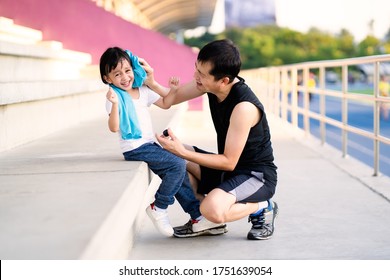 Asian Father Is Wiping Sweat For The Little Daughter And They Talking And Laugh Together While Resting For Jogging Time, Concept Of Parent Care And Support For Kid Outdoor Activity On Family Lifestyle