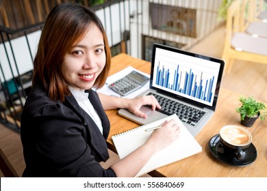 Asian Female Accountant Or Banker Making Calculations. Savings, Finances And Economy Concept.