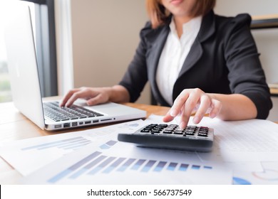 Asian female accountant or banker making calculations. Savings, finances and economy concept.