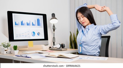 Asian Female Accountant Is Tired From Working In A Chair, Stretching To Relax And Relax While Working Hard At The Office.