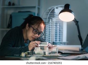 Asian Female Architect Model Building Design. Working From Home. She Works Late At Night.