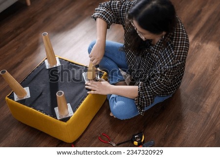 asian female assembly of furniture with hand tools at home 