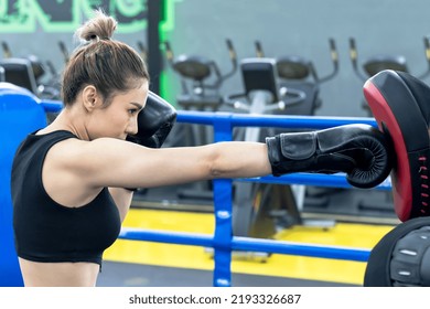 Asian Female Boxer Wearing Boxer Gloves Punching Punch Bag In Boxing Gym