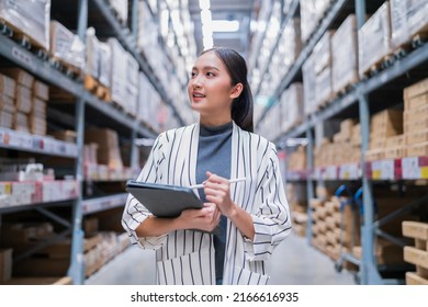 asian female business owner using digital tablet checking amount of stock product inventory on shelf at distribution warehouse factory.logistic business shipping and delivery logistic service