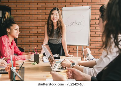 Asian Female Business Woman Leader Conducting The Meeting With Her Multiethic Colleagues In The Office