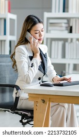 Asian female businesswoman search computer information while talking with client mobile phone. Manager agent solve help to company customer distantly modern tech usage, busy fruitful workday concept - Shutterstock ID 2213732105