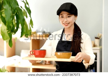 Asian female clerk carrying food in store