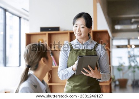 Asian female clerk taking orders at a cafe