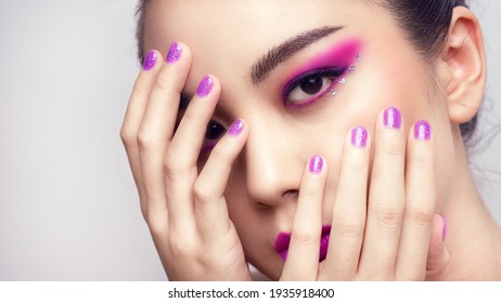 Asian female closeup colorful eyeshadow with extreme long false eyelashes. Eyelash Extensions. Makeup, Cosmetics, Beautiful cosmetics makeup concept.