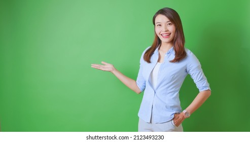 asian female confident anchor or business woman is showing something on green background - Powered by Shutterstock