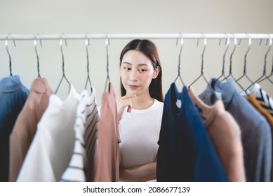 Asian Female Considering Cloth To Wear On Date Night.