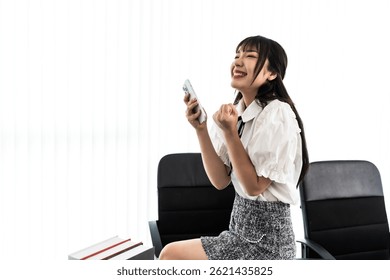 Asian female content creator looking at smartphone feeling happy with successful increasing subscribers and  followers