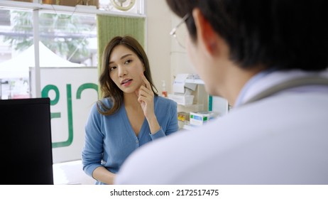 Asian female customer comes to consult about acne and wrinkles on the face with a pharmacist, Thai text in background : Pharmacy - Powered by Shutterstock