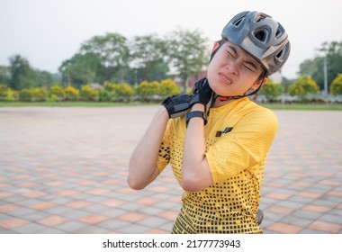 Asian female cyclist having neck pain from riding a bike long time. Poor posture is a major contributor to neck pain whilst cycling.