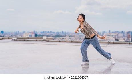 Asian Female Dancer Showing Contemporary And Modern Dance Performance On Rooftop Of Highrise Building In Urban