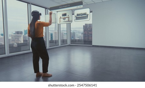 Asian female designer wearing virtual reality headset uses AI augmented reality interior design app to arrange office workspace or stylish apartment with 3D furniture and equipment. 3D visual effects.