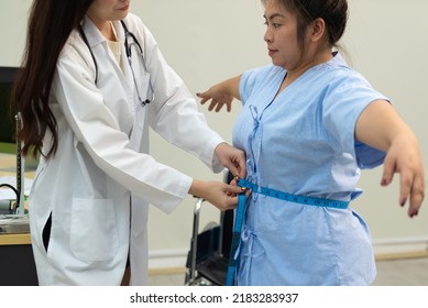 Asian Female Doctor Checking A Fat Woman's Body At Hospital.