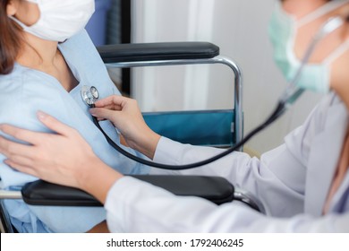 Asian Female Doctor Is Checking The Symptoms Of A Female Patient With A Stethoscope In The Disease Control Area. Concepts Of Care And Treatment For Patients With COVID 19.