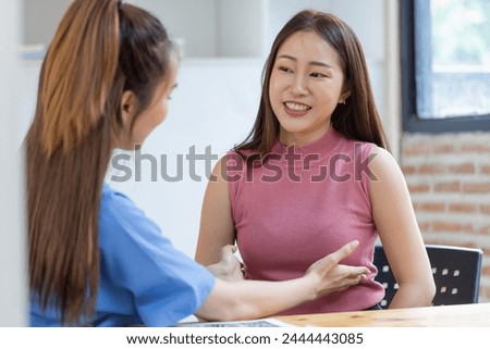 Asian female doctor examining breast cancer patients in hospital.