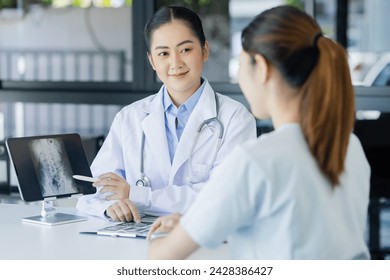 Asian female doctor explain to patient indoors office, healthcare and medical concept. - Powered by Shutterstock