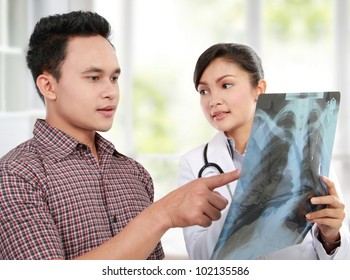 Asian Female Doctor Explaining Lung Xray To Patient