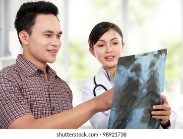 Asian Female Doctor Explaining Lung Xray To Patient