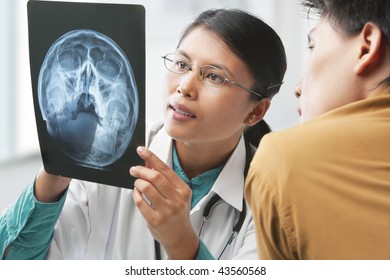 Asian Female Doctor Explaining Skeleton Xray To Patient