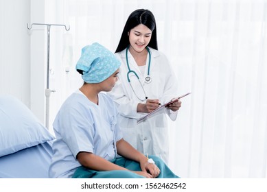 Asian Female Doctor Explaining Treatment Procedures And Health Insurance Plans For Women With Cancer Patients While The Patient Sits On The Bed, With White Background, To Health Care Concept.