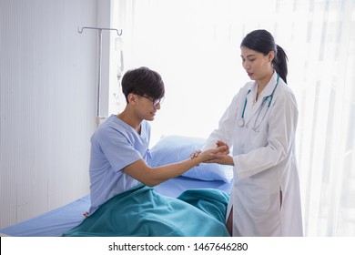 Asian Female Doctor Hold The Pulse At The Male Patient’s Wrist See Heart Rate. Alternative Medicine Chinese Doctor Diagnosis Of Annual Physical Examination Concept.