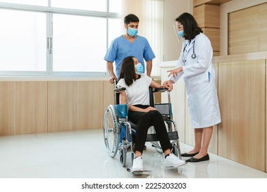 Asian Female Doctor With Male Nurse Wearing Protective Face Mask Reassured And Consult Young Woman Patient Before Surgery Treatment At Hospital.