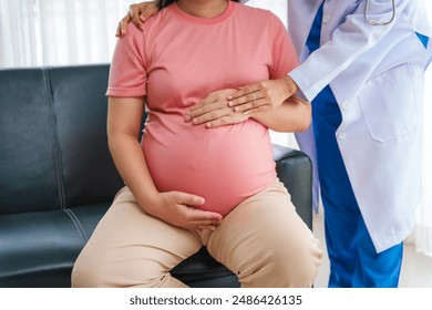 Asian female doctor nurse encouragement to a pregnant woman on a sofa, using ultrasound and stethoscope, addressing medical conditions like edema, varicose veins, and pregnancy-induced hypertension. - Powered by Shutterstock