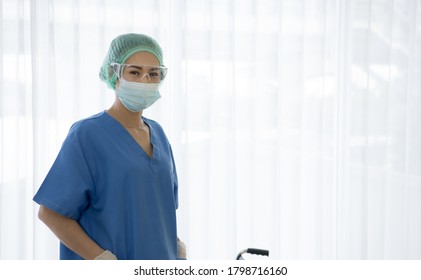 Asian Female Doctor Or Nurse Wearing Medical Protective Mask And Glasses On Face. Protection For Coronavirus COVID-19