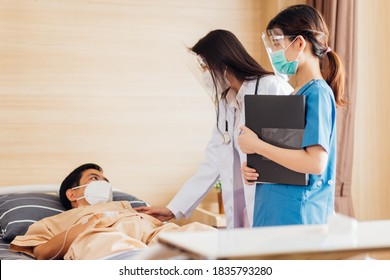 Asian Female Doctor And Nurse Wearing Mask Checking Health Of Senior Old Patient In Hospital Recovery Room. Woman Medic Checking Heart Rate Pulse And Giving Health Care Advisory.