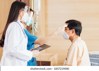 Asian Female Doctor And Nurse Wearing Mask Checking Health Of Senior Old Patient In Hospital Recovery Room. Woman Medic Checking Heart Rate Pulse And Giving Health Care Advisory.