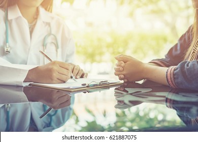 Asian female Doctor and patient are discussing something ,Having Consultation,Medical physician working in hospital writing a prescription, Healthcare and medically concept,selective focus - Shutterstock ID 621887075