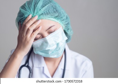 Asian Female Doctor In Stress Tired Overworked Sad Sleeping, Wearing Stethoscope Protective Surgical Mask And Hair Net, Medical Health Care Provider.