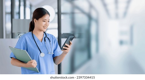 Asian female doctor using smartphone with patient clipboard standing in hospital, Medicine and healthcare concept. - Powered by Shutterstock